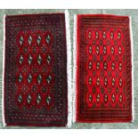 A pair of Persian Baluch woollen handmade rugs with geometric design on a red ground, each approx