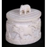 An early 20th century carved ivory lidded box decorated with a chain of elephants, 10cms (4ins)