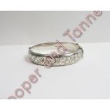 A silver hinged bangle, half engraved decoration, cased