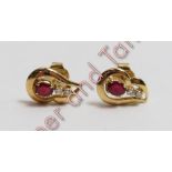 A pair of ruby and diamond earstuds, unmarked, the oval cut with a pair of small brilliant cuts