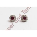 A pair of ruby and diamond cluster earstuds, in unmarked white metal, the round cut stones