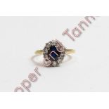 A sapphire and diamond cluster ring, stamped '18ct', the oval cut stone enclosed by ten brilliant