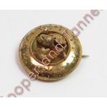 A Victorian unmarked gold brooch, of circular outline, decorated with an acorn and oak leaves,