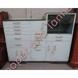 A mid century dentists cabinet, set with various multiple drawers, sliding glass section and