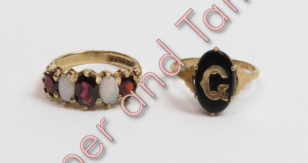 A 9 carat gold five stone opal and garnet ring, finger size M; with an initial ring stamped '9ct',