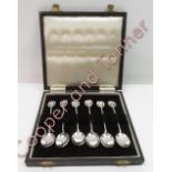 A cased set of six silver coffee spoons, Birmingham 1930, the finials pierced and engraved with