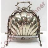 A silver plated folding muffin warmer, the shell shaped warmer on rustic supports, 24cm high by 23cm