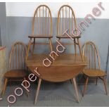 An Ercol beech and elm circular table and chairs, 71cm high, 112cm high, 121cm diameter