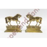 A pair of brass door stops, each in the form of trotting horses