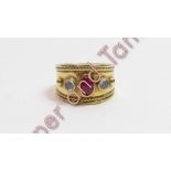 An 18 carat gold three stone ruby and moonstone dress ring, finger size R, 14.5 g gross