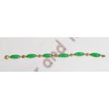 A jade bracelet, stamped '14k', the six long oval panels with oriental characters between, 19 cm