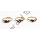 A trio of 9 carat gold rings, each set with a cabochon between a trefoil of beads at each