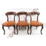 Five Victorian mahogany dining chairs, each with a tan leather seat raised on cabriole legs