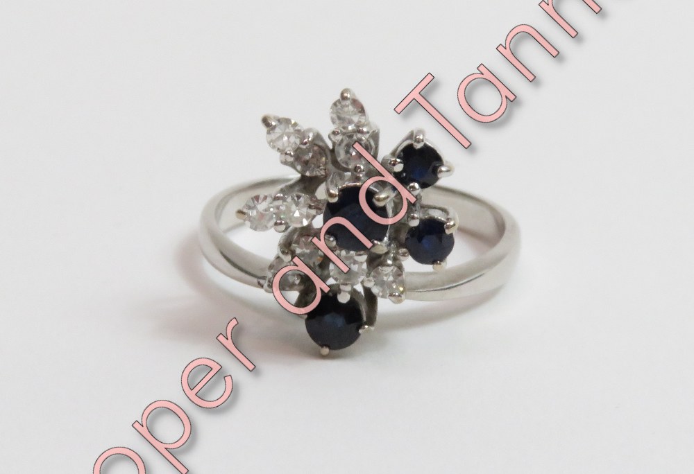 A sapphire and diamond cluster ring, the white mount stamped '18ct', set with four sapphires and ten