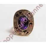 A 9 carat gold single stone amethyst ring, with a pierced and engraved wide border, 10.4 g gross,