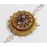 A Victorian gem set unmarked gold brooch, of circular outline, decorated with a vari-gem cluster