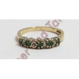 A 9 carat gold five stone emerald half hoop ring with pairs of small diamonds between, finger size