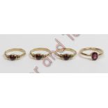 A trio of 9 carat gold single stone garnet rings, each set with a cabochon between a trefoil of