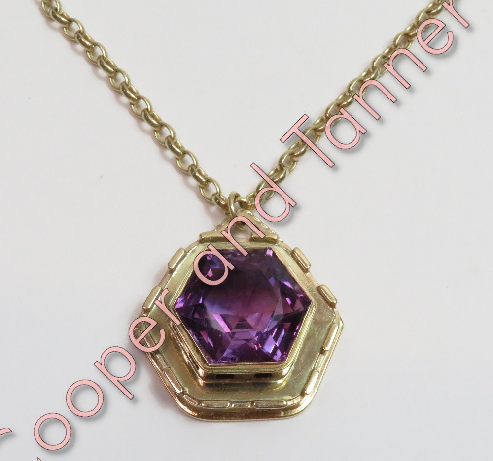 A 9 carat gold amethyst pendant on a 9 carat gold chain, the hexagonal cut stone in a similarly