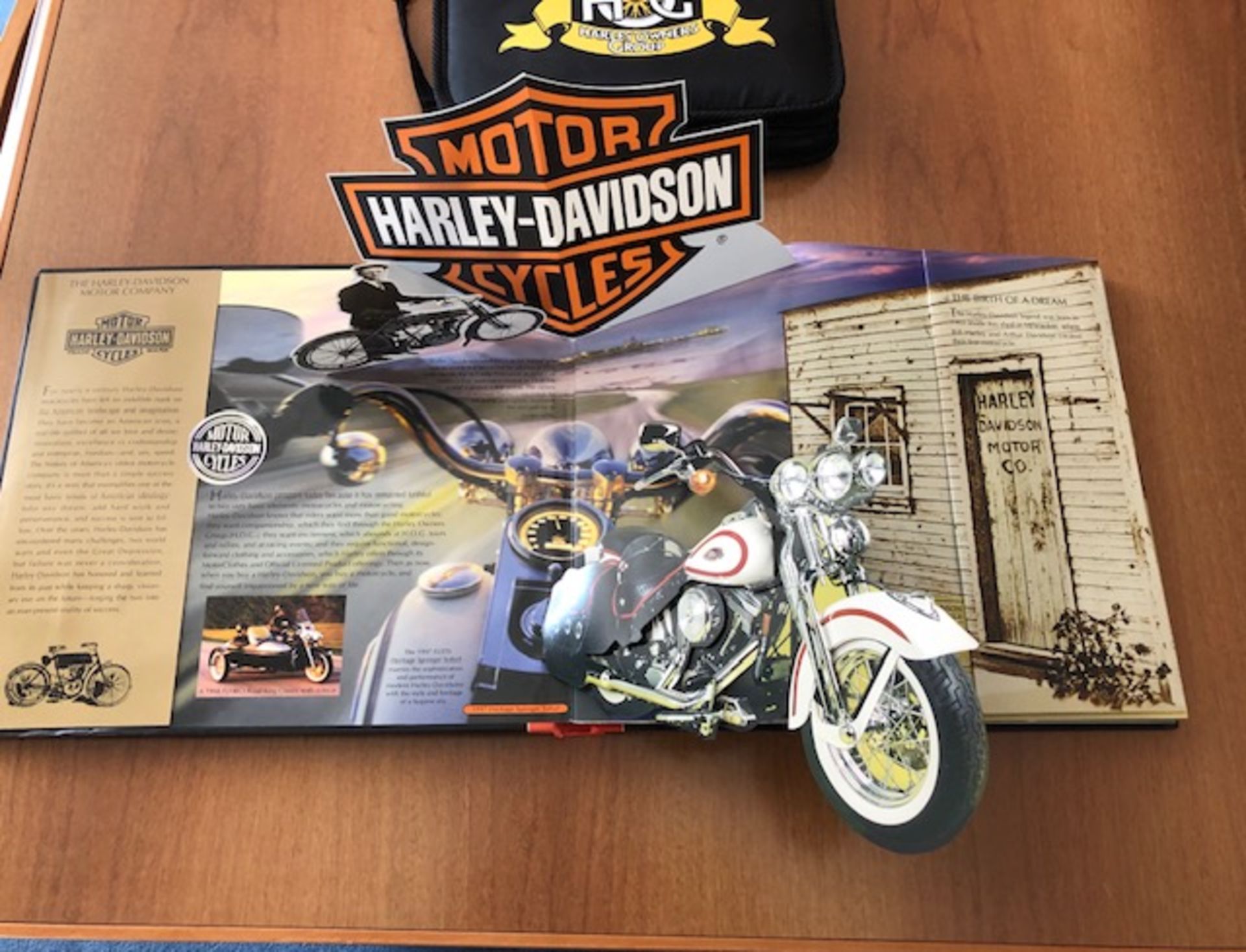 Harley Davidson pop up book in good condition and wallet containing H.O.G. books and badges