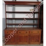 A 19th Century oak dresser with open rack top, the base fitted with three short drawers above