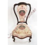 A Victorian mahogany framed nursing chair with shaped seat and cabriole front supports with scroll