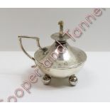 A silver table lighter; makers mark rubbed, London 1909, the hemispherical body on four ball