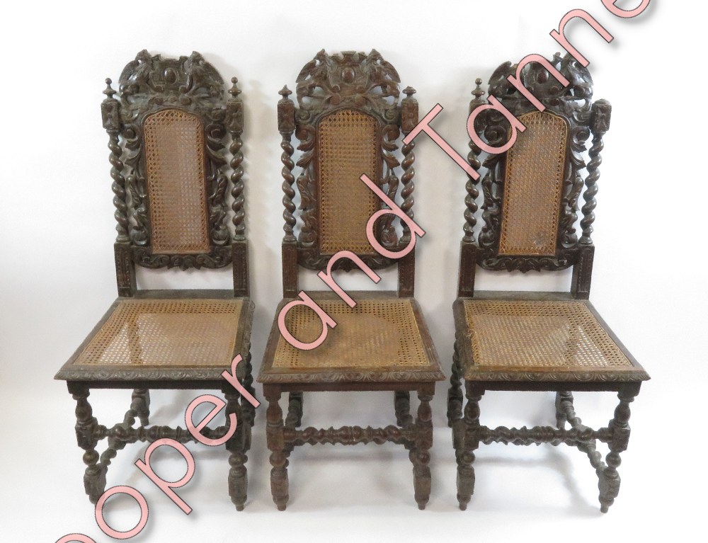 A set of four carved oak dining chairs in the Jacobean style with cane backs and seats