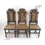 A set of four carved oak dining chairs in the Jacobean style with cane backs and seats