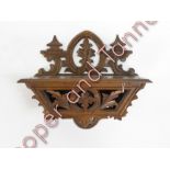 A late 19th/early 20th Century Black Forest carved wood wall mounted candle box, 27cms high 32cms