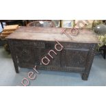 An 18th Century oak coffer with carved panelled sides and front and on stile supports, 71cms high