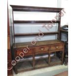 A late 18th Century oak dresser with open rack top, the base fitted with three short drawers above