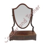 A George IV shield shaped swing dressing mirror the base fitted with two short drawers and on ogee