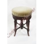 A Victorian circular adjustable piano stool with upholstered seat and on turned supports and