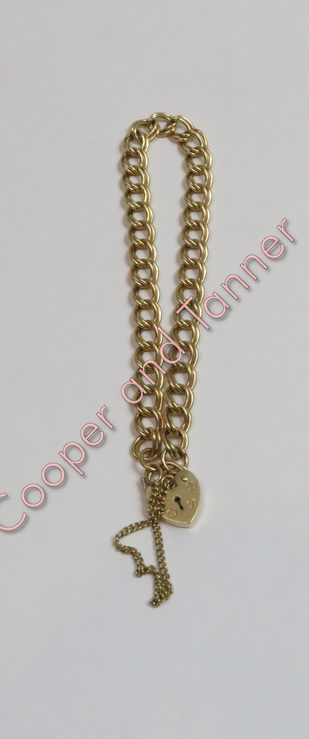 A 9 carat gold bracelet, of double curb links, to a padlock clasp, 19 cm long, 7.7 g gross