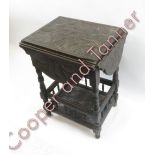 A late Victorian carved oak table with drop flaps to each side and galleried lower tier on turned