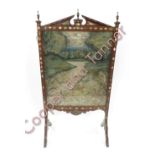 A late Victorian walnut framed fire screen with abalone inlay, the central panel with silkwork of