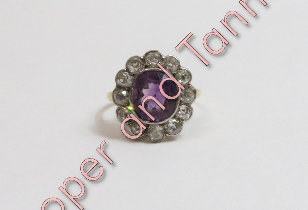 An amethyst and diamond cluster ring, unmarked, the oval cut amethyst enclosed by twelve old