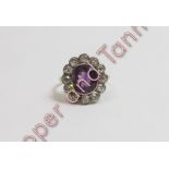 An amethyst and diamond cluster ring, unmarked, the oval cut amethyst enclosed by twelve old