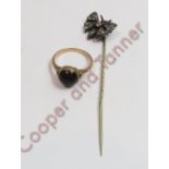 An unmarked cabochon garnet set ring, finger size M, 3.5 g gross; with a paste set butterfly