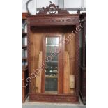 A 19th Century Continental oak wardrobe surmounted by pair of carved wood figures leaning against