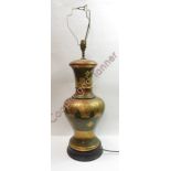 A large decorative table lamp of baluster form with incised decoration and large brown shade