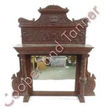 A Victorian carved oak over mantel mirror worked with lions mask, mythical creatures and foliage,