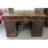 An early 20th century pedestal desk with a green leather insert, one long drawer, eight smaller