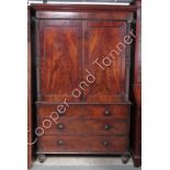 A Victorian mahogany linen press the upper section with panelled doors enclosing single sliding