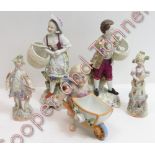 A pair of 19th Century German figures of a boy and a girl each holding a basket, on rococo style