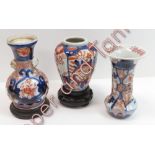 Two small Japanese Imari vases on hardwood stands, 11.5cms and 12cms high and an ovoid Imari vase