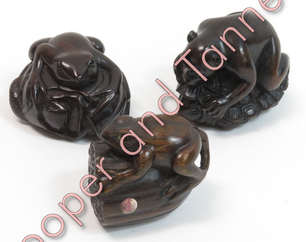 Three reproduction carved hardwood netsuke - a monkey on a turtle; frog on lilly bud and another