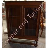 A circa 1930's oak book case having pair of leaded glass doors enclosing adjustable shelves, with