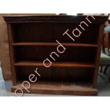 An early 20th Century oak open bookcase having two adjustable shelves, with foliate carved frieze